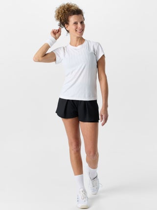 Woman modeling a white performance t-shirt and black tennis shorts.