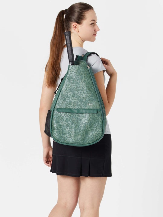 Image of model carrying the Glove It Tennis Backpack in a green print