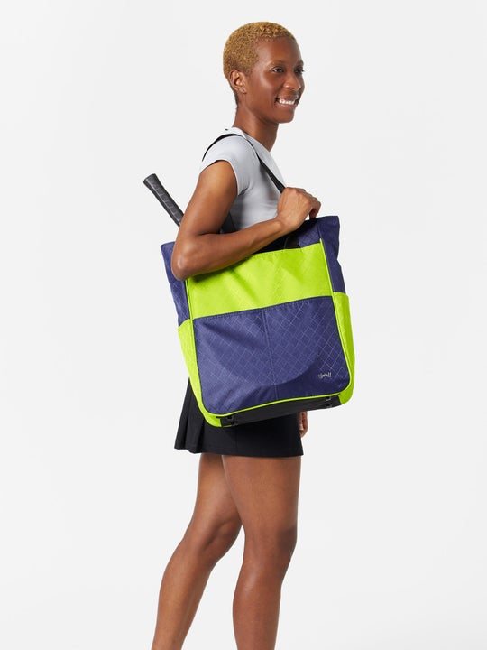 Model carrying the Glove It Signature Tennis Tote in navy/green