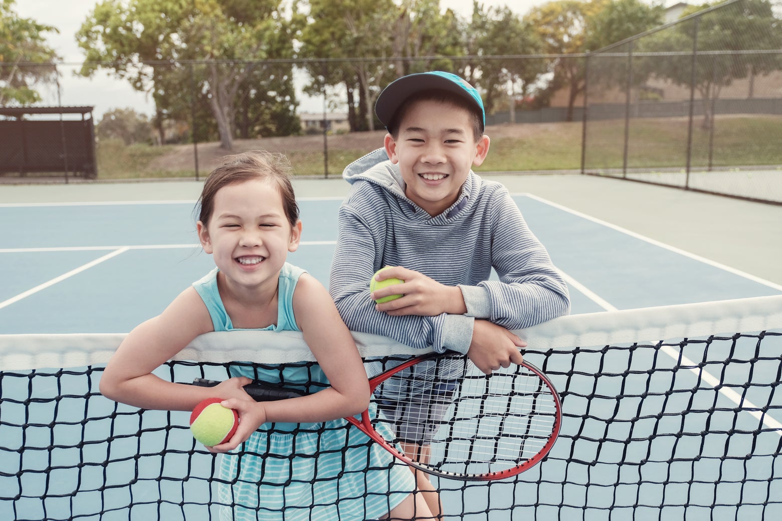 Young tennis players standing at the net.