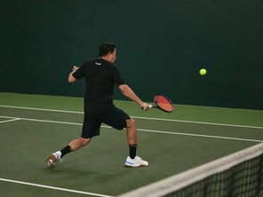 Image of a TW player hitting a volley. 