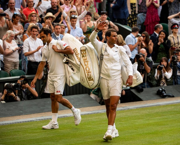 Nadal and Federer wave goodbye to the crowds at Wimbledon after their last match.