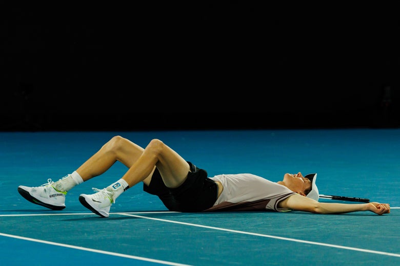 Jannik Sinner falls to the ground after winning his first Grand Slam title. 