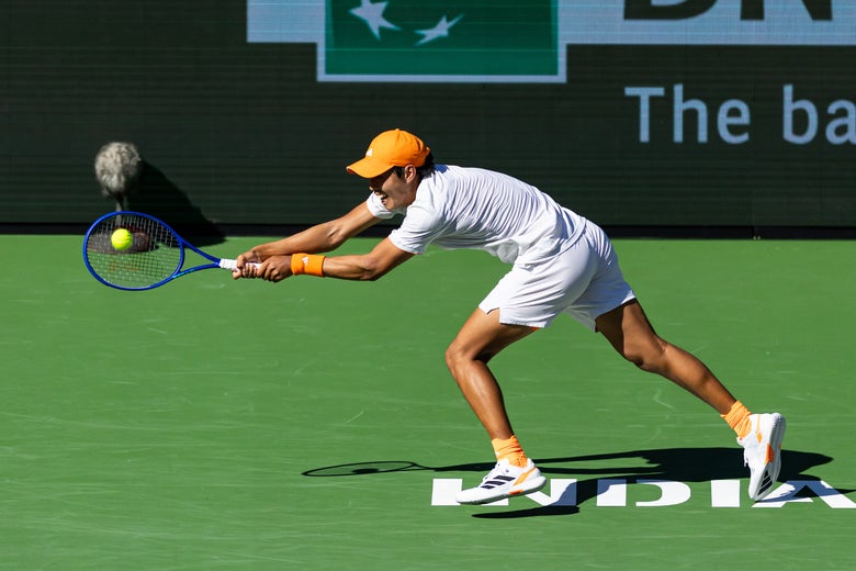 Image of Learner Tien reaching wide for a backhand. 