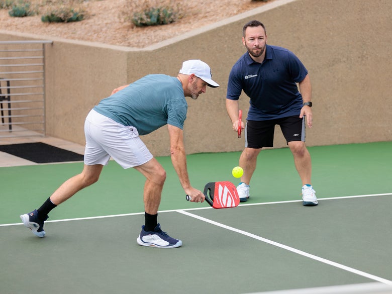 Pickleball player hitting a third shot drop playing doubles