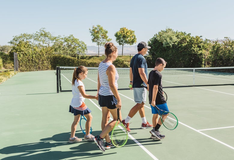 Family walking onto the tennis court