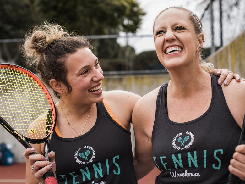 Two smiling women tennis players