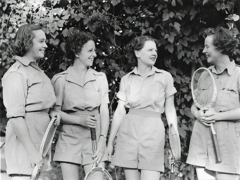 Historical image of women with wood tennis racquets wearing shorts and polos