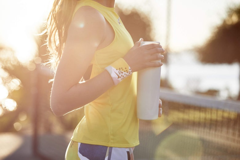 Woman holding a water bottle and wearing wristbands