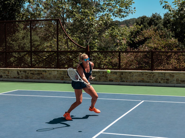 Image of Playtester Hitting a Forehand Volley wearing blue sunglasses