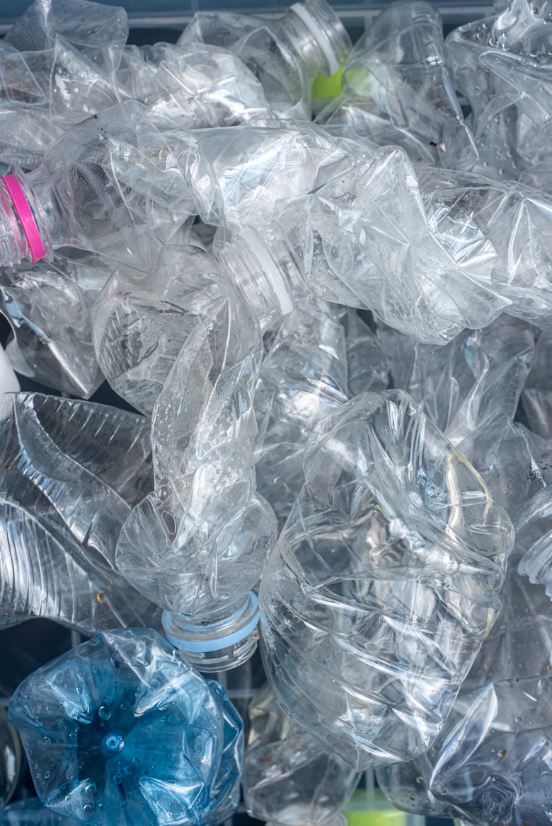 crushed empty water bottles being readied for recycling