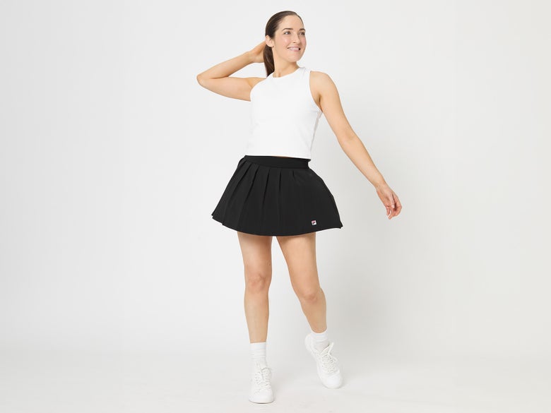 Model wearing the Fila Essentials Pleat Skirt in Black with a white tank top.