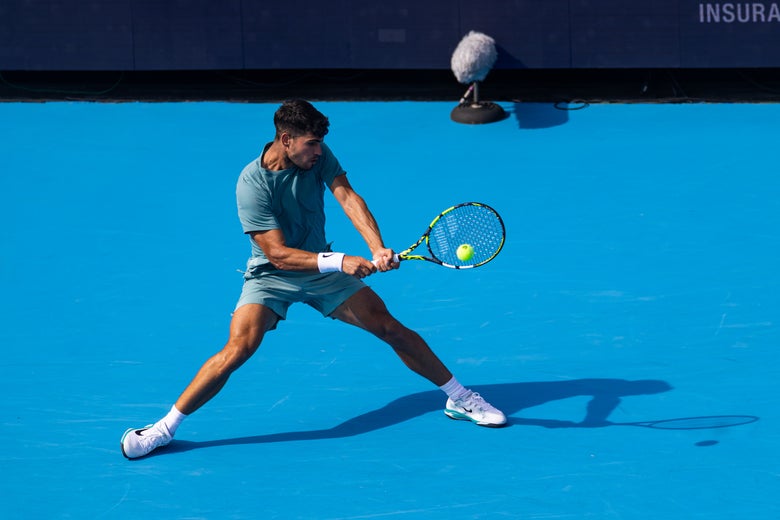 Carlos Alcaraz leans into a backhand. 