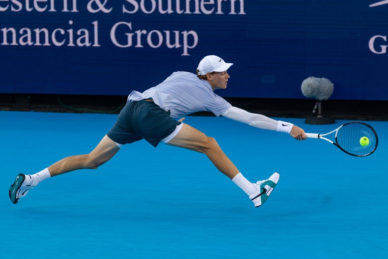 Jannik Sinner stretches for a backhand out wide. 