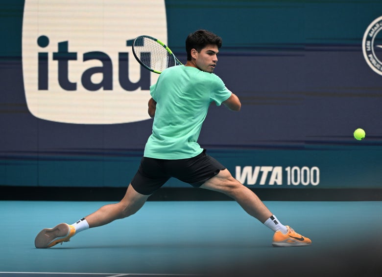 Carlos Alcaraz slides into a backhand. 