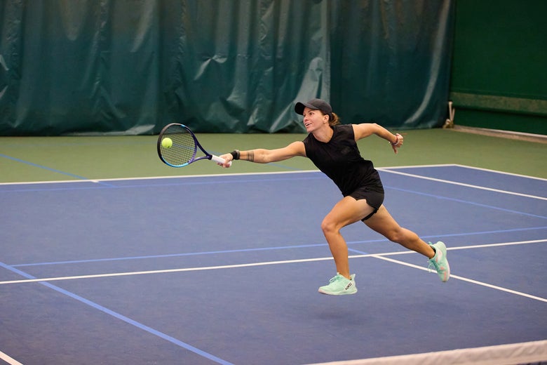 Playtester Zsofi lunging for a forehand volley wearing the K-Frame Speed shoes in green