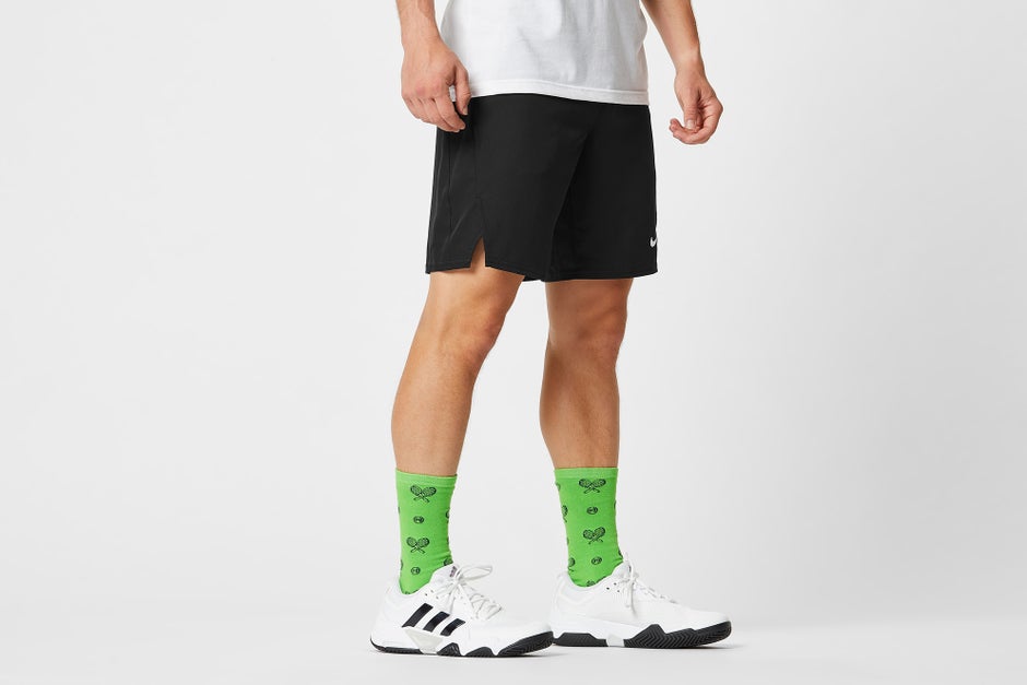 Green socks with tennis graphics and white shoes. 