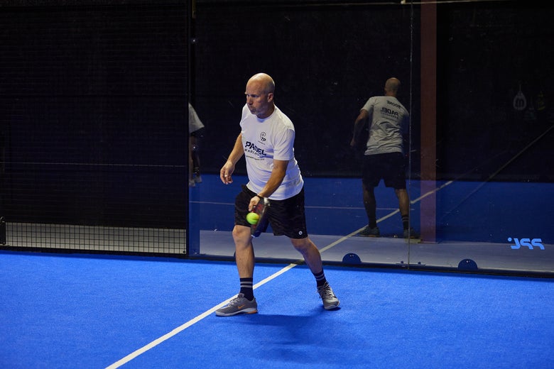 Image of a Padel Warehouse player defending on the right side.