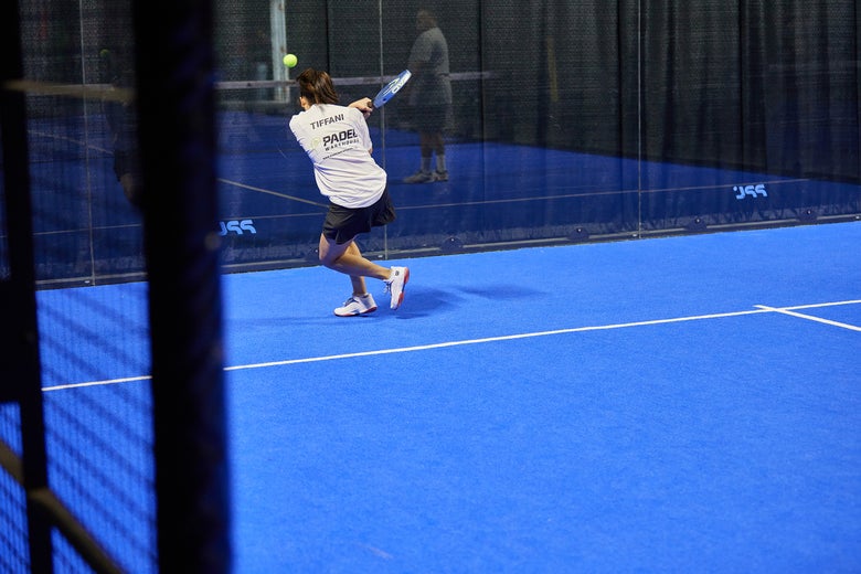 Image of a Padel Warehouse playtester hitting a lob off the back wall.