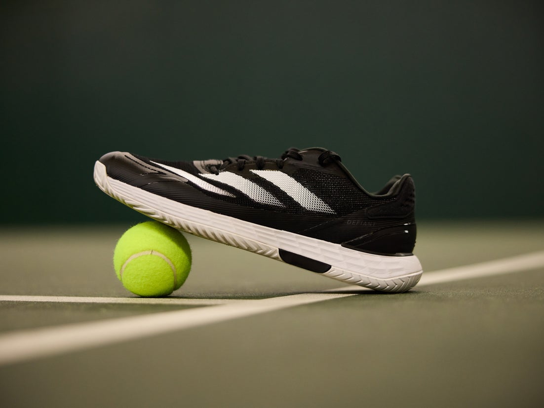 Black and white adidas Defiant Speed 2 displayed sitting on a tennis ball