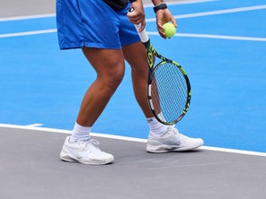 Image of a Closeup of Legs Hitting a Serve